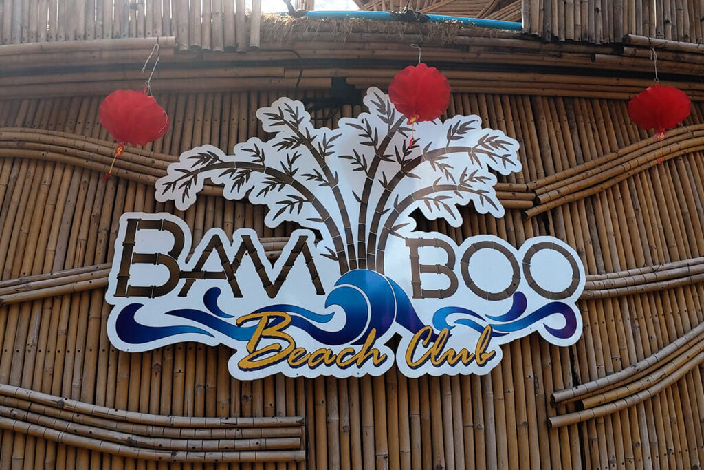Bamboo Beach Club logo mounted on a curved natural bamboo wall