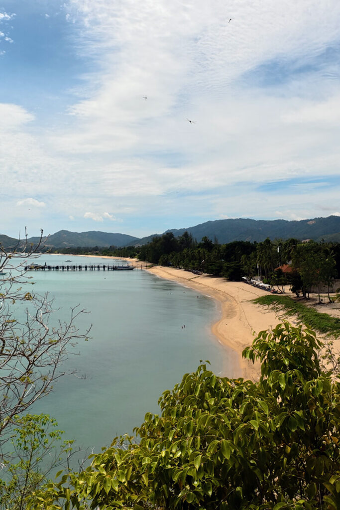 Elevated panoramic view looking over the sweeping golden sand bay and mountains of Maenam Beach Koh Samui