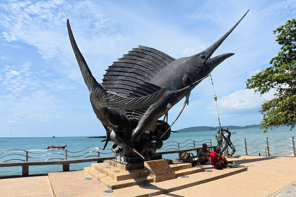 Large black marlin and fishermen bronze sculpture overlooking the sea along the Ao Nang promenade