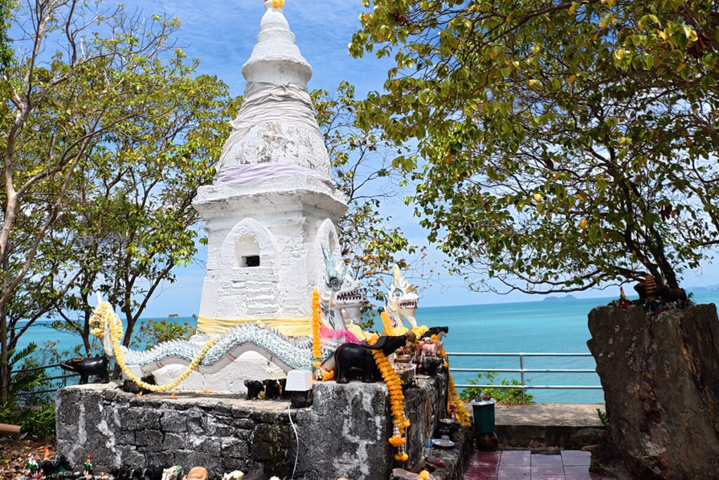Traditional white Buddhist stupa with dragon carvings overlooking the sea at Maenam Viewpoint in Koh Samui